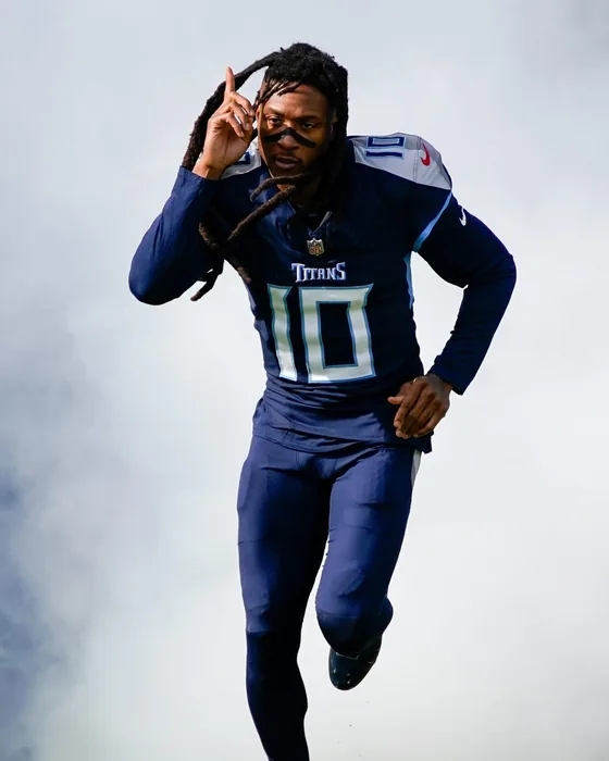 DeAndre Hopkins running onto the field in a Tennessee Titans uniform.